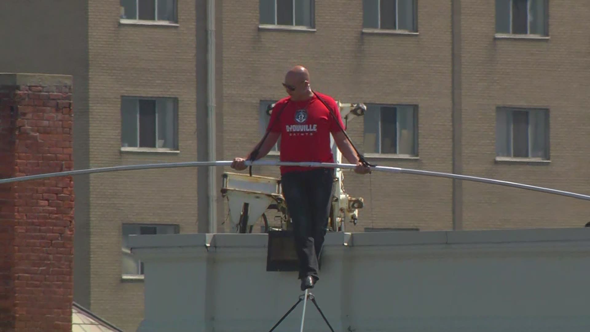 Nik Wallenda walks high wire above D'Youville campus.  Wallenda was on hand to help open the college's new HUB facility