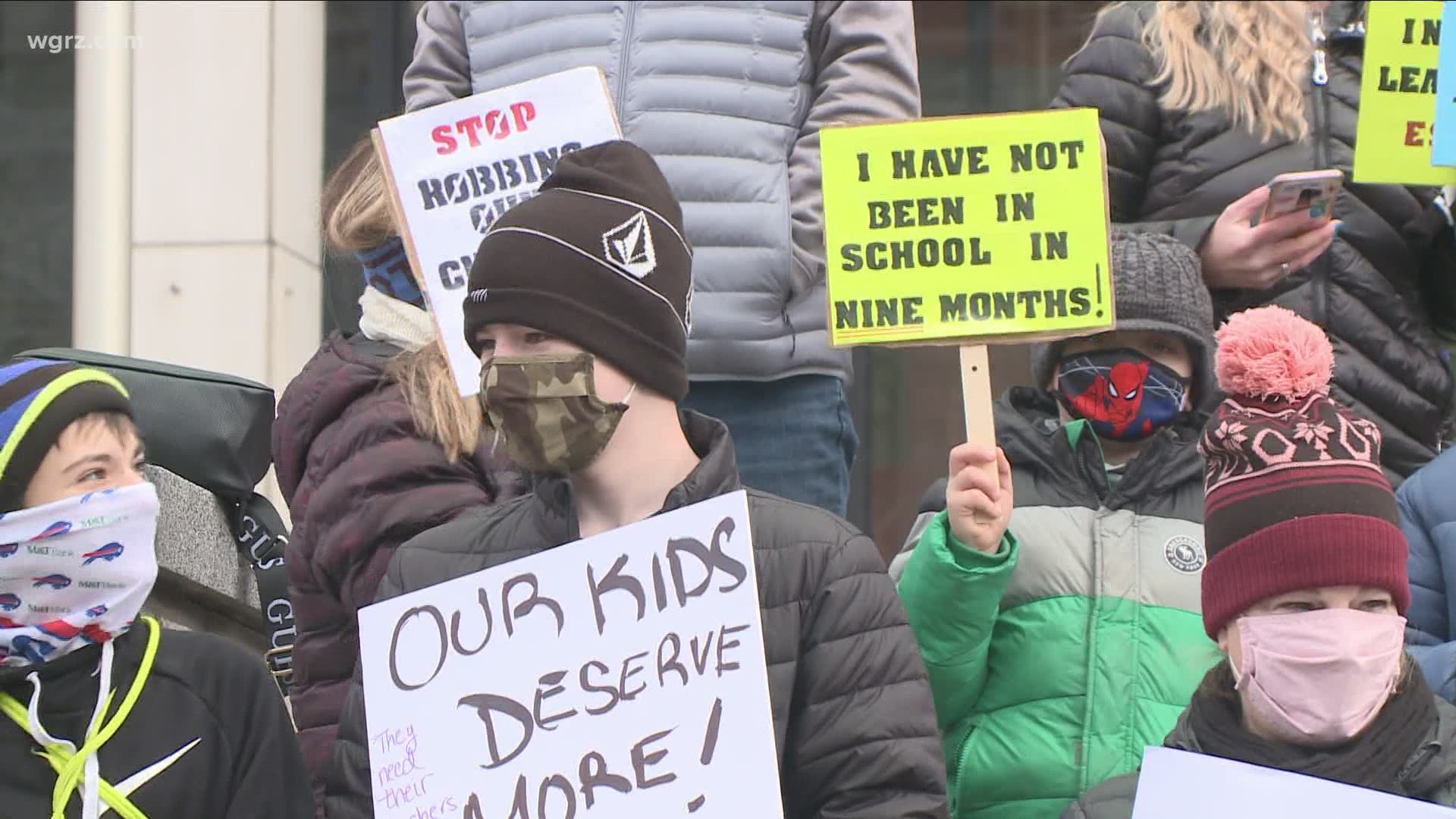 The Rath Building protest comes just two days after the state released new relaxed COVID-19 testing guidelines for schools in certain color zones.