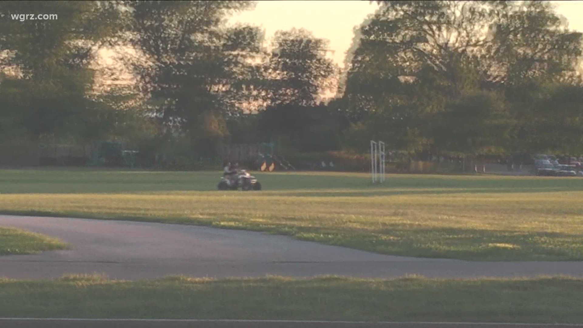 ATV operator and a passenger speed through Front Park on Buffalo's West Side. ATV's and dirt bikes are illegal in the city.