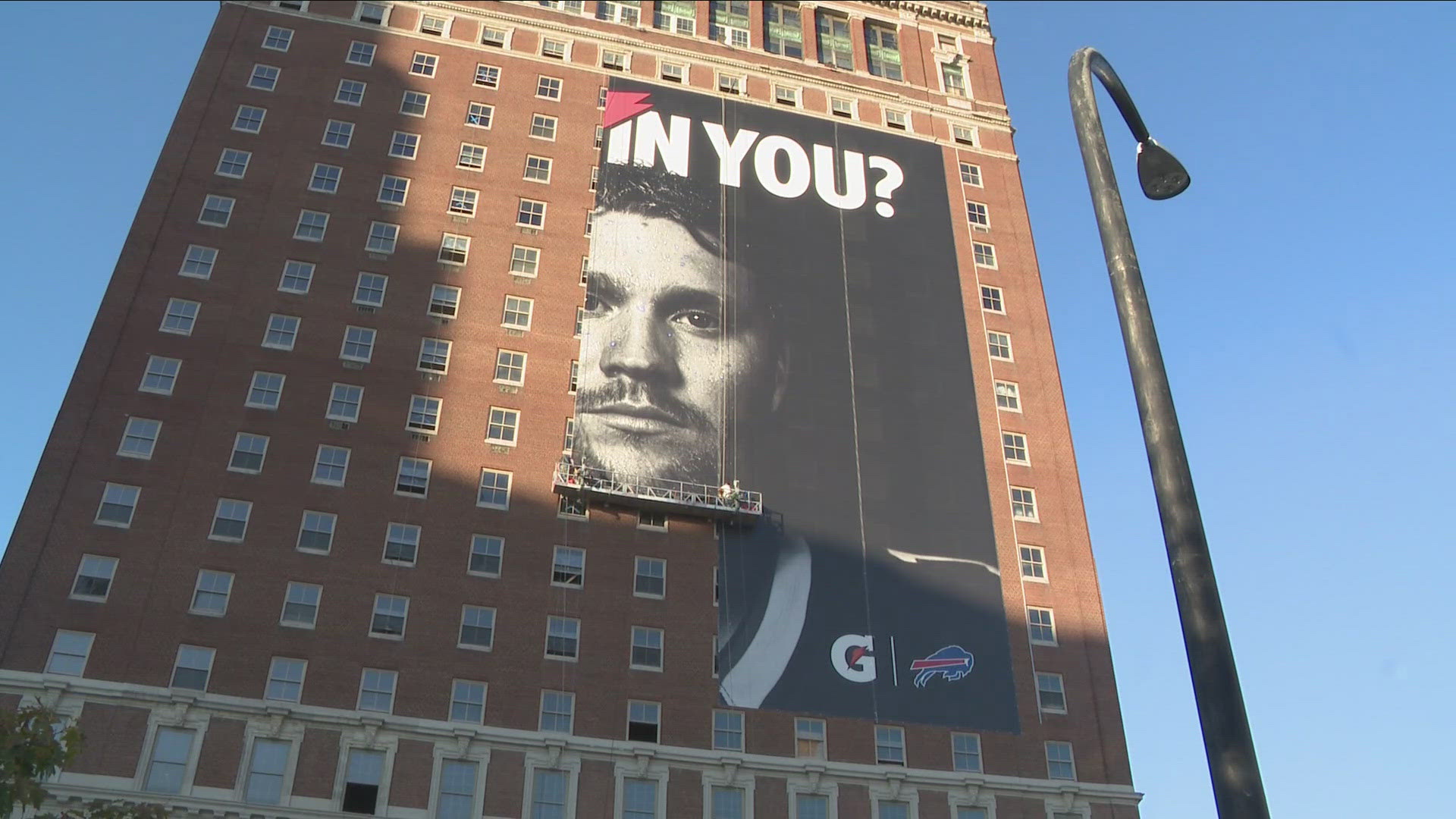 Workers on Saturday took down the "IS IT IN YOU?" campaign poster overlooking Niagara Square, found on the side of the Statler building.