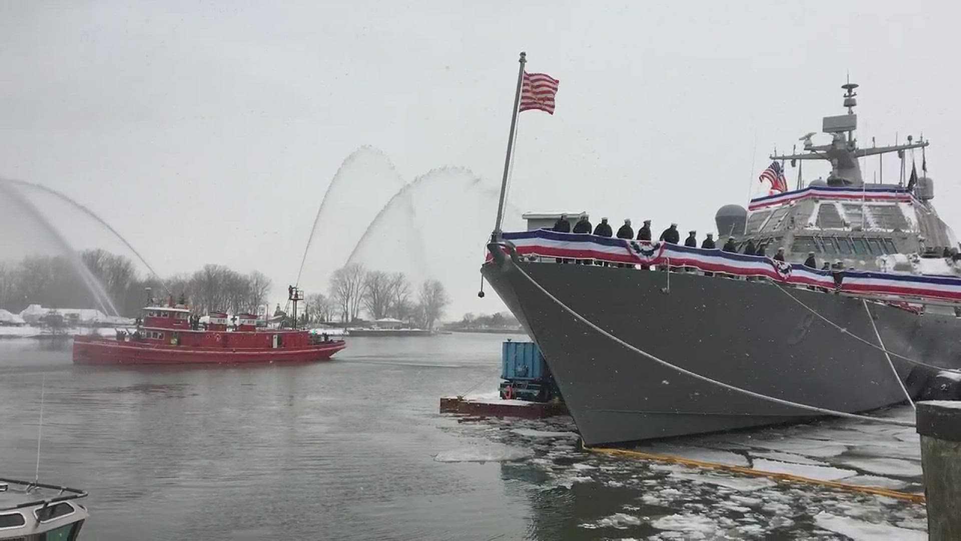 The Edward M. Cotter fire boat passes by the new USS Little Rock with a water cannon salute.